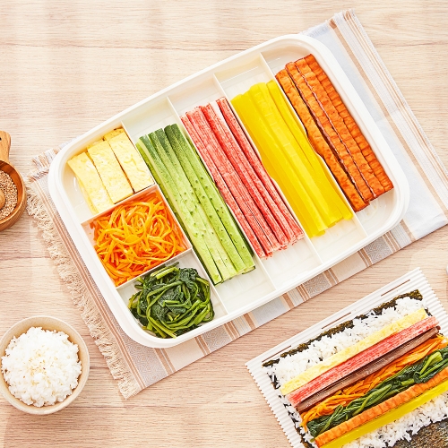 Kimbap fillings prepared and laid out -- stir-fried carrot, blanched spinach, egg strips, and ham slices
